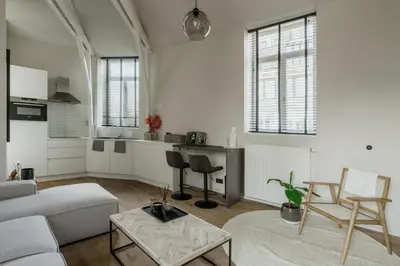 a living room with a couch and a table at Mooi licht appartement in bruisend Antwerpen! in Antwerp