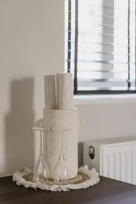 a table with two wine glasses and a roll of paper towels at Mooi licht appartement in bruisend Antwerpen! in Antwerp