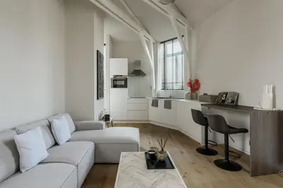 a white living room with a couch and a table at Mooi licht appartement in bruisend Antwerpen! in Antwerp