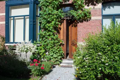 a door to a brick building with flowers and plants at B&B Woluwé in Brussels