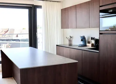 a kitchen with wooden cabinets and a counter top at Ghent Penthouse in Ghent