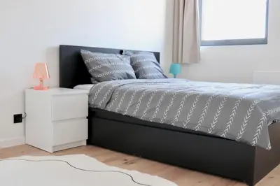 a bedroom with a bed and a white nightstand at Ghent Penthouse in Ghent