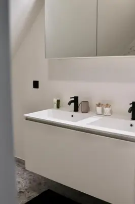a bathroom with a white sink and a mirror at Ghent Penthouse in Ghent