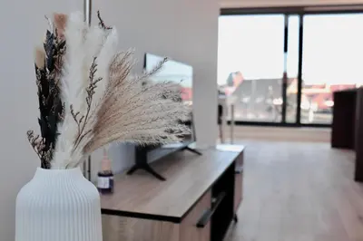 a white vase with feathers in a room with a desk at Ghent Penthouse in Ghent