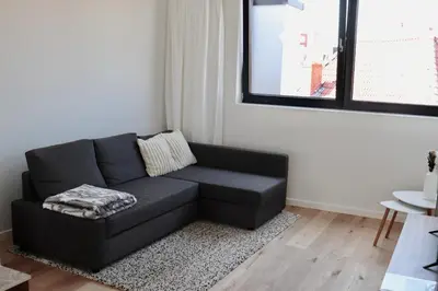 a black couch in a living room with a window at Ghent Penthouse in Ghent