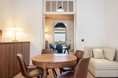 a dining room and living room with a table and chairs at Jardin du Béguinage - Peaceful Luxury Home in Brussels in Brussels
