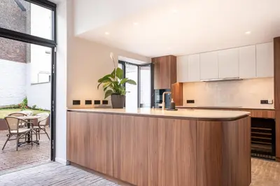 a kitchen with a wooden counter and a table at Jardin du Béguinage - Peaceful Luxury Home in Brussels in Brussels