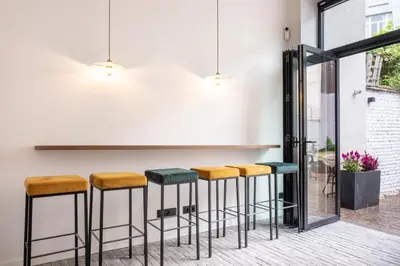 a bar with stools in front of a wall at Jardin du Béguinage - Peaceful Luxury Home in Brussels in Brussels