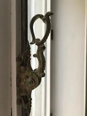 a metal door handle on a white door at Jardin du Béguinage - Peaceful Luxury Home in Brussels in Brussels