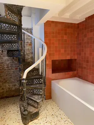 a bathroom with a staircase next to a bath tub at Jardin du Béguinage - Peaceful Luxury Home in Brussels in Brussels