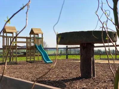 a playground with two swings and a slide at Square Shaped Farmhouse from 1713 in Nieuwenhove