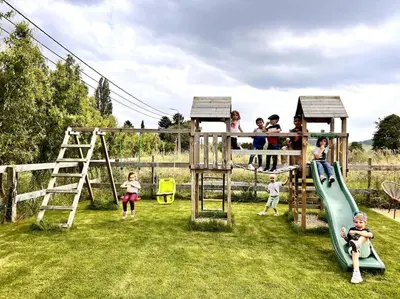 a group of children playing on a playground at Square Shaped Farmhouse from 1713 in Nieuwenhove