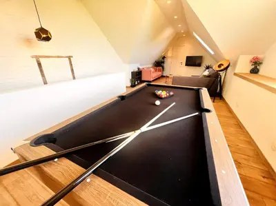 a pool table in the middle of a living room at Square Shaped Farmhouse from 1713 in Nieuwenhove
