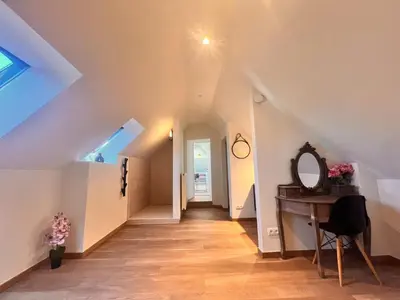 an attic hallway with a mirror and a desk at Square Shaped Farmhouse from 1713 in Nieuwenhove