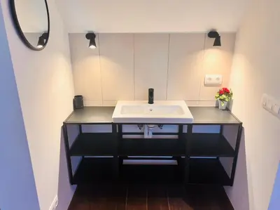 a bathroom with a sink and a mirror at Square Shaped Farmhouse from 1713 in Nieuwenhove