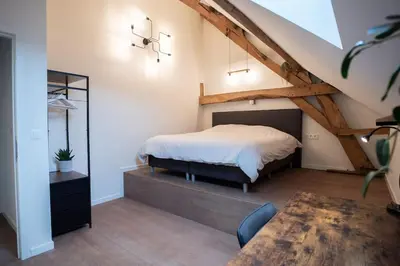 a bedroom with a bed in a attic at Square Shaped Farmhouse from 1713 in Nieuwenhove