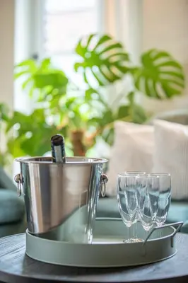 a metal bucket and two wine glasses on a table at Boonackere Cottage in Oosterzele