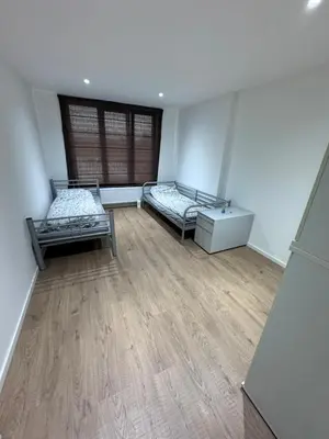 a room with two beds and a wooden floor at House 5 minutes walk to Tomorrowland in Boom