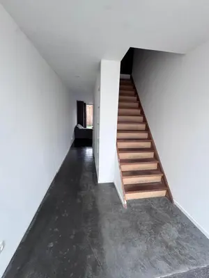 a staircase in a room with white walls and concrete floors at House 5 minutes walk to Tomorrowland in Boom