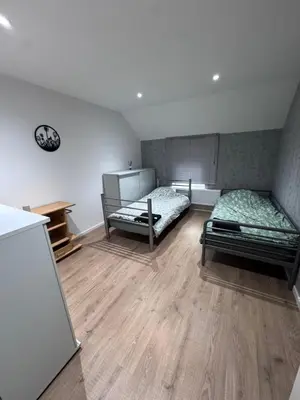 a room with two beds and a wooden floor at House 5 minutes walk to Tomorrowland in Boom