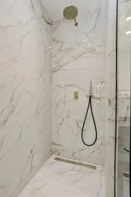 a bathroom with a shower with white marble walls at Deluxe 2-BR Apartment in Antwerp in Antwerp