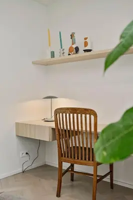 a wooden chair sitting in front of a desk at Deluxe 2-BR Apartment in Antwerp in Antwerp
