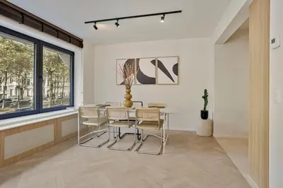a dining room with a table and chairs and a window at Deluxe 2-BR Apartment in Antwerp in Antwerp