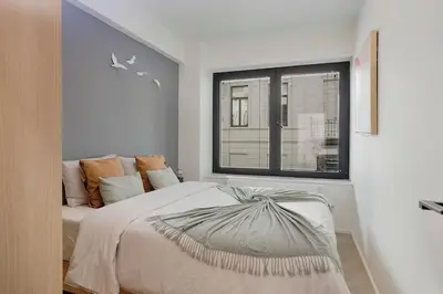 a bedroom with a large bed and a window at Deluxe 2-BR Apartment in Antwerp in Antwerp