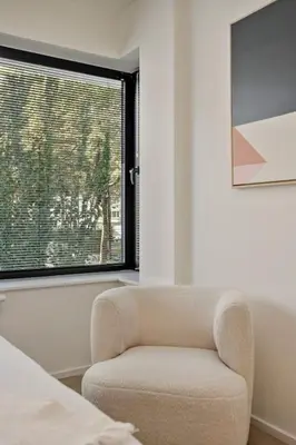 a living room with a chair and a window at Deluxe 2-BR Apartment in Antwerp in Antwerp