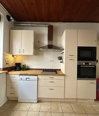 a kitchen with white cabinets and a stove top oven at CasaVerde Family House With Duplex Suite in Ghent