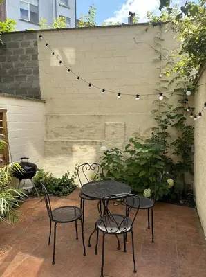 a patio with two tables and chairs and a wall at CasaVerde Family House With Duplex Suite in Ghent