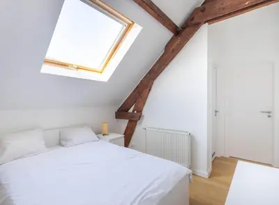 a bedroom with a white bed and a window at Élégance Cinquantenaire in Brussels
