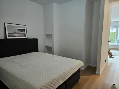 a bedroom with a bed in a white room at Centre de Bruxelles Merveilleux ! in Brussels
