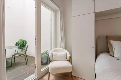 a bedroom with a chair and a mirror at 1-BR Centre Antwerp Haven with Patio in Antwerp