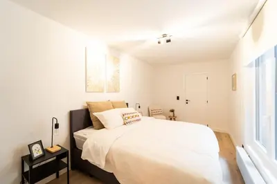 a bedroom with a large white bed and a window at Your Antwerp Adventure Sleeps 4 in Antwerp