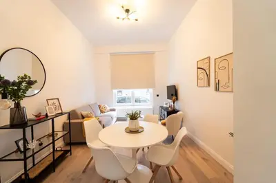 a white living room with a table and chairs at Your Antwerp Adventure Sleeps 4 in Antwerp