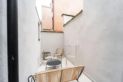 a balcony with chairs and a table and a building at Your Antwerp Adventure Sleeps 4 in Antwerp