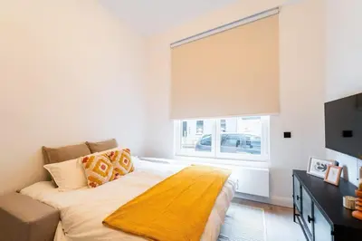 a bedroom with a bed with a yellow blanket on it at Your Antwerp Adventure Sleeps 4 in Antwerp