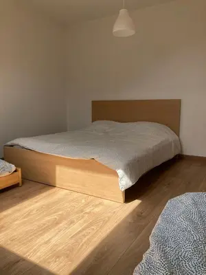 a bedroom with a bed and a wooden floor at Bright appartement in Zaventem