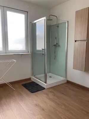 a glass shower in a room with a window at Bright appartement in Zaventem