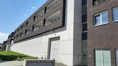 a building with a white garage door and a brick building at Brussels Base Camp in Brussels