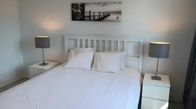 a bedroom with a white bed with two lamps at Brussels Base Camp in Brussels