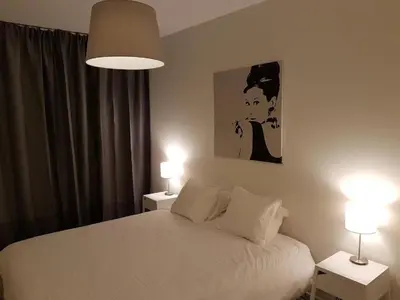 a bedroom with a white bed and two lamps at Brussels Base Camp in Brussels