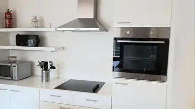 a kitchen with white cabinets and a stove top oven at Brussels Base Camp in Brussels