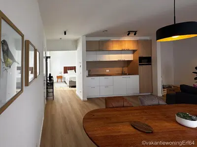a kitchen and living room with a table in a room at Vakantiewoning Erf64 in Sint-Amands