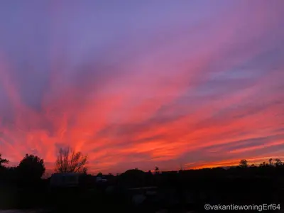 a sunset with a red in the sky at Vakantiewoning Erf64 in Sint-Amands
