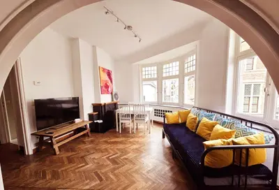 a living room with a couch and a tv at Résidence Marianne in Brussels