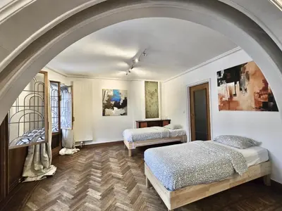 a bedroom with two beds and an archway at Résidence Marianne in Brussels