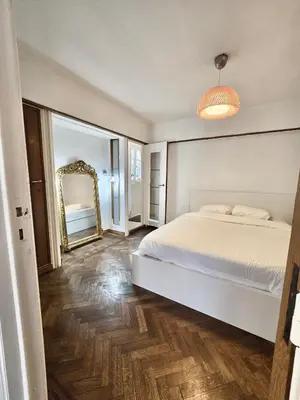 a bedroom with a white bed and a mirror at Résidence Marianne in Brussels