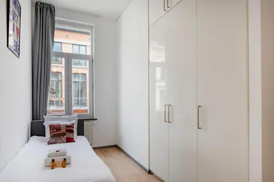 a small bedroom with a bed and a window at Brussels Flagey Elegant in Brussels